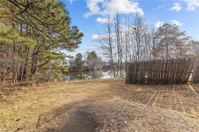 view of yard with a water view and fence