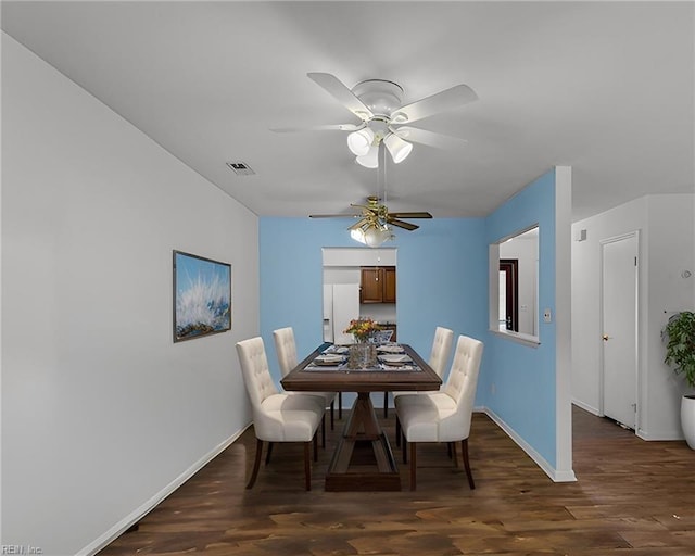 dining room featuring a ceiling fan, wood finished floors, visible vents, and baseboards