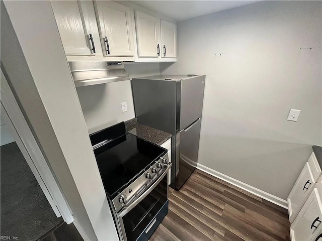 kitchen featuring stainless steel electric range, dark wood-type flooring, white cabinets, under cabinet range hood, and baseboards