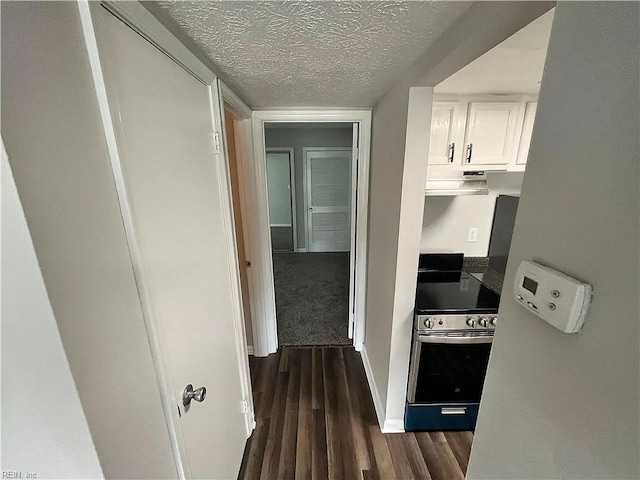 corridor featuring a textured ceiling, dark wood finished floors, and baseboards