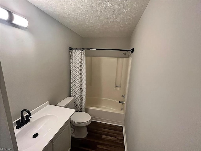 full bathroom featuring a textured ceiling, toilet, wood finished floors, vanity, and shower / tub combo with curtain