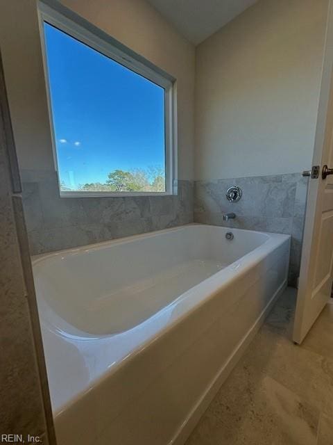 bathroom with a bath and tile patterned floors