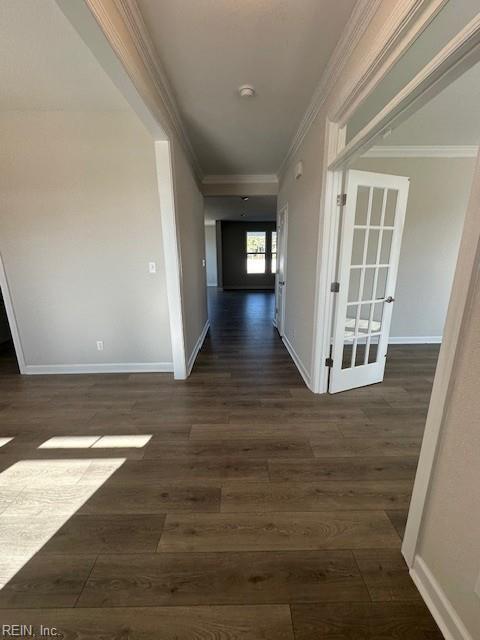 hall featuring ornamental molding, dark wood finished floors, and baseboards