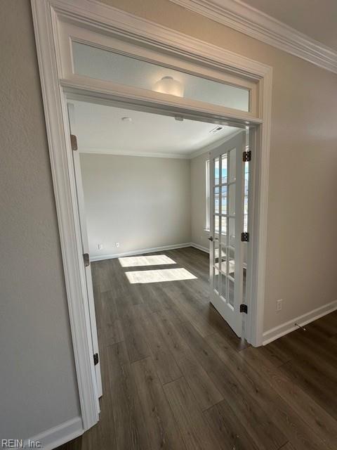 hallway with baseboards, dark wood-type flooring, and crown molding