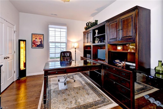 office area featuring wood finished floors, visible vents, and baseboards