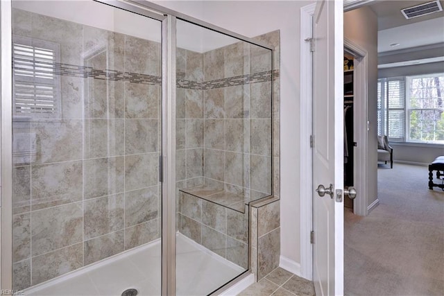 bathroom with a stall shower and visible vents