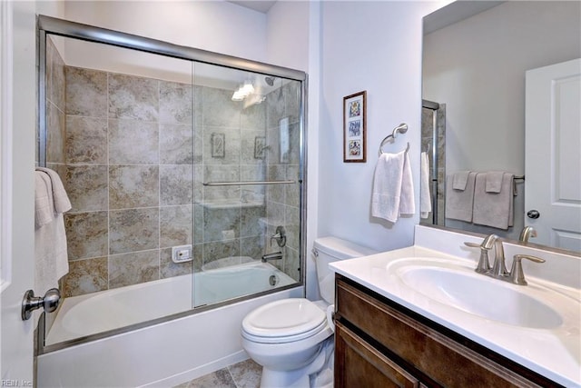 bathroom featuring enclosed tub / shower combo, vanity, and toilet