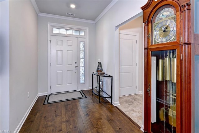 foyer with ornamental molding, visible vents, baseboards, and dark wood-style floors