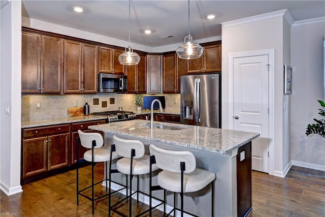 kitchen with decorative backsplash, appliances with stainless steel finishes, dark wood-style flooring, and a sink