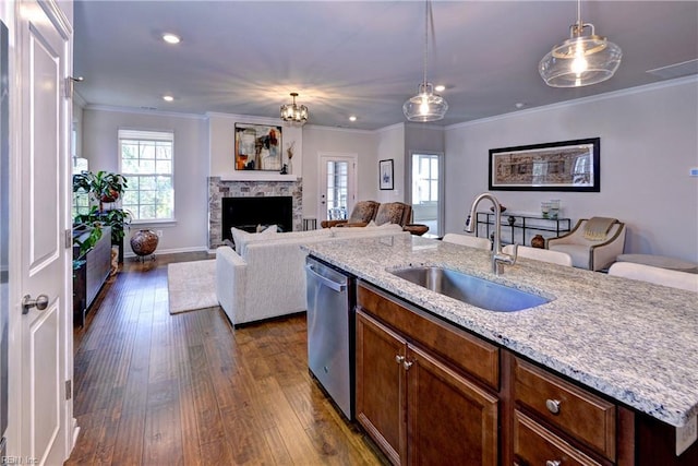 kitchen featuring dishwasher, hanging light fixtures, dark wood-style flooring, and a sink