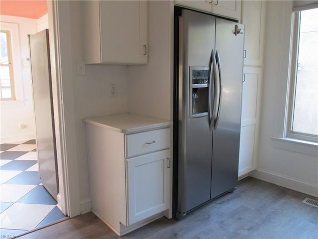 kitchen with light countertops, stainless steel fridge, plenty of natural light, and light floors