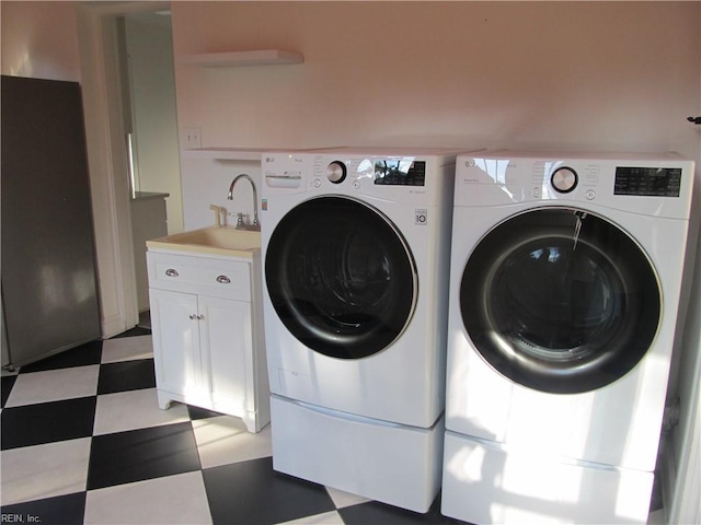 laundry area with light floors, a sink, cabinet space, and washer and dryer