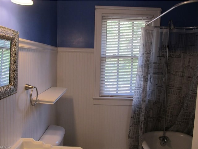 bathroom featuring toilet and wainscoting