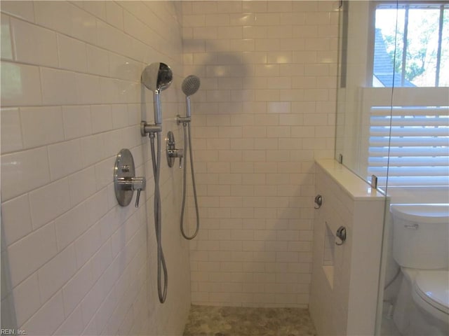 bathroom with toilet and a tile shower