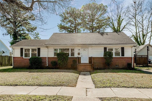 ranch-style home with crawl space, fence, a front lawn, and brick siding