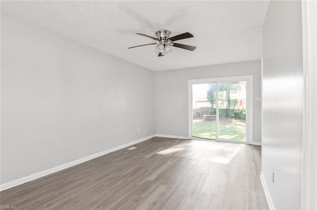 unfurnished room featuring a ceiling fan, baseboards, and wood finished floors