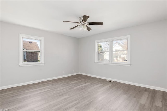 spare room with a ceiling fan, baseboards, and wood finished floors