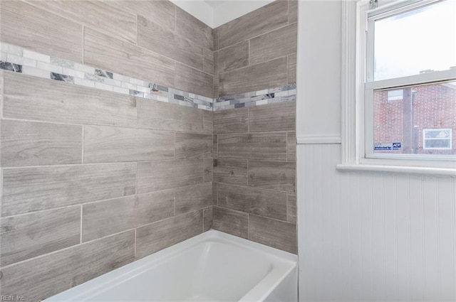 bathroom with wainscoting and tub / shower combination