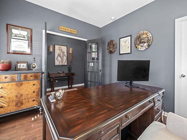 home office featuring baseboards and wood finished floors