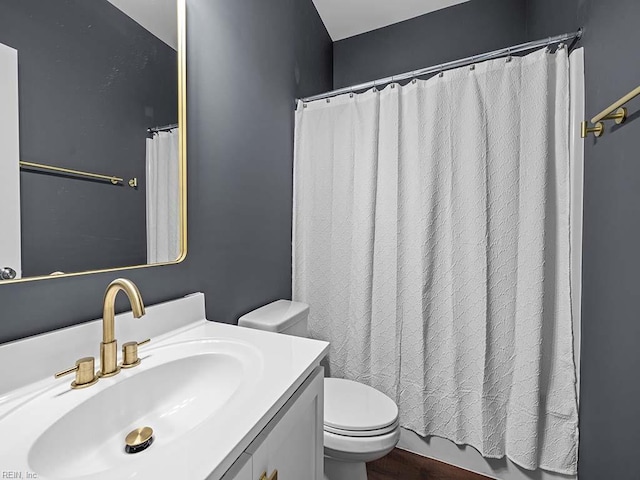 bathroom with curtained shower, vanity, and toilet