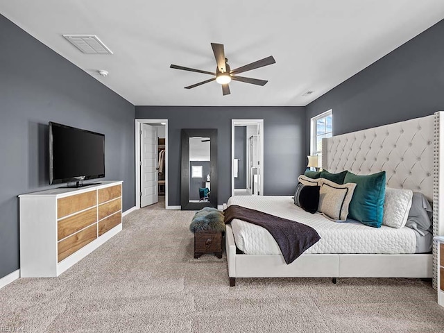 carpeted bedroom with a closet, visible vents, a ceiling fan, connected bathroom, and baseboards