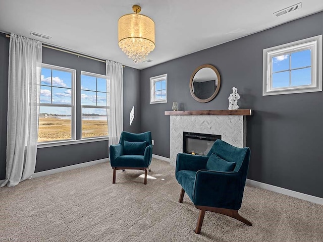 sitting room with baseboards, visible vents, and a tiled fireplace