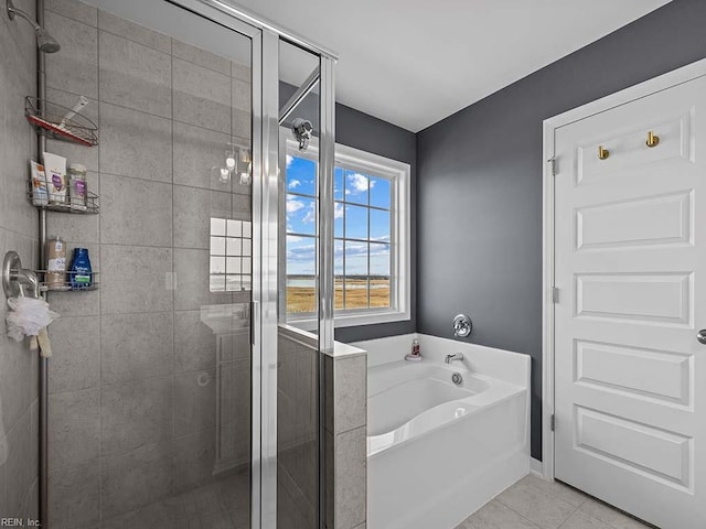 bathroom featuring tile patterned flooring, a shower stall, and a bath