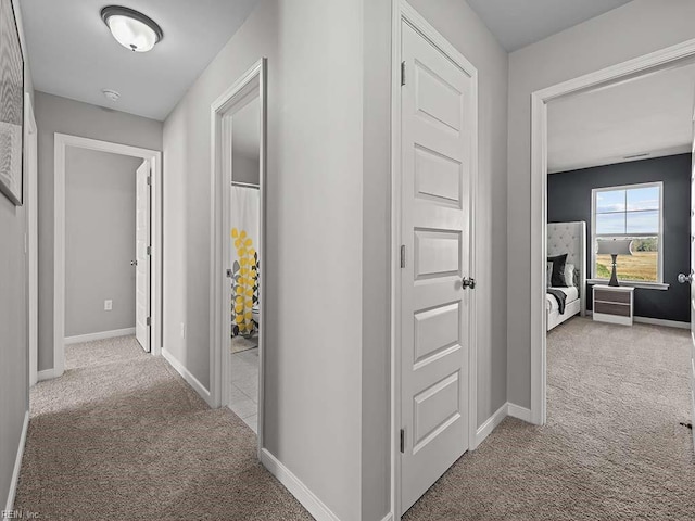 corridor with carpet floors and baseboards