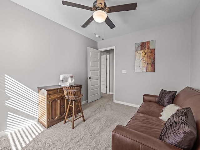 office featuring baseboards, ceiling fan, and light colored carpet