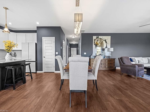 dining room featuring baseboards, dark wood finished floors, a notable chandelier, and recessed lighting