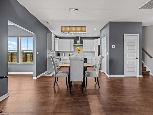 dining area featuring stairs, dark wood-type flooring, visible vents, and baseboards