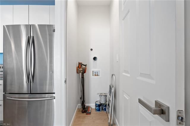 interior space with light wood-style floors, baseboards, hookup for a washing machine, and laundry area