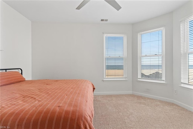 bedroom featuring light carpet, baseboards, visible vents, and ceiling fan