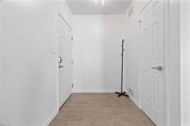 interior space featuring baseboards, visible vents, and light wood-style floors