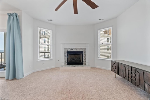 unfurnished living room with light carpet, plenty of natural light, and visible vents