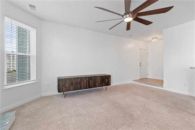 empty room with baseboards, carpet, visible vents, and a ceiling fan