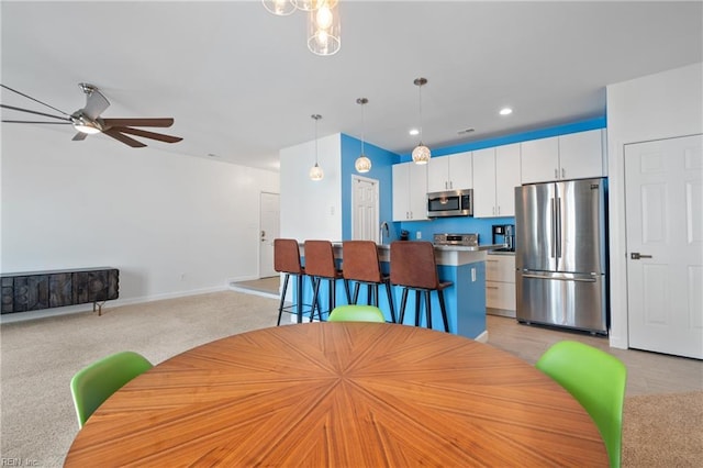 dining area with light carpet, ceiling fan, recessed lighting, and baseboards