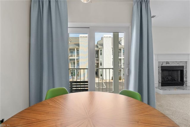 dining room featuring carpet and a fireplace