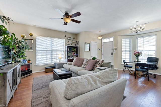 living area featuring a healthy amount of sunlight, baseboards, and wood finished floors