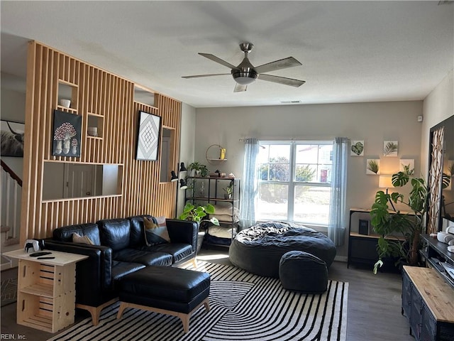 living area featuring visible vents, a ceiling fan, and wood finished floors