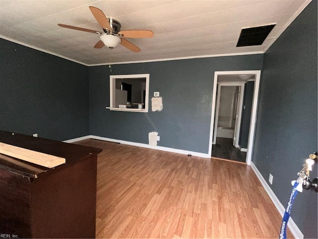 interior space with baseboards, visible vents, ornamental molding, and wood finished floors