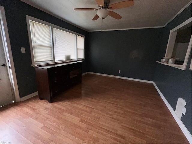 spare room featuring ceiling fan, ornamental molding, wood finished floors, and baseboards