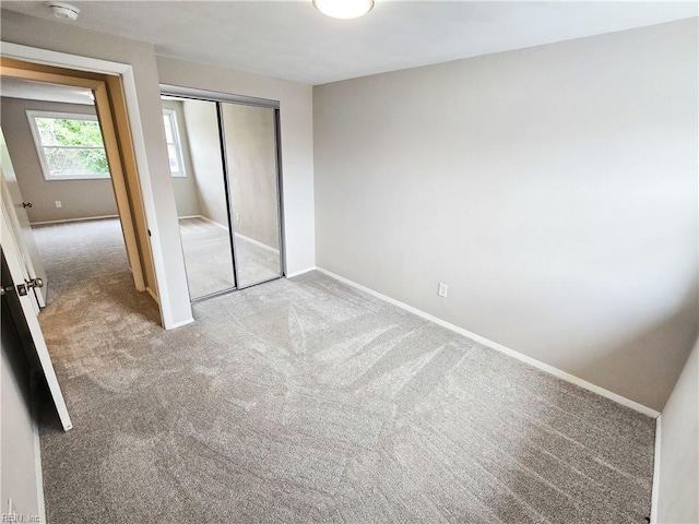 unfurnished bedroom featuring a closet, carpet, and baseboards