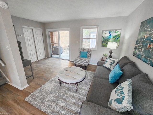 living area featuring stairs, baseboards, and wood finished floors