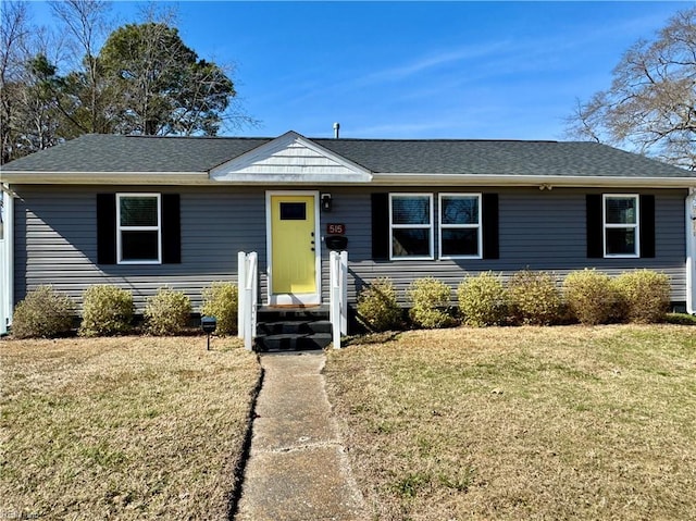 ranch-style house featuring a front yard, roof with shingles, and entry steps