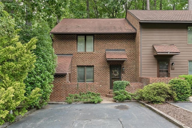 view of front of house with brick siding and a shingled roof