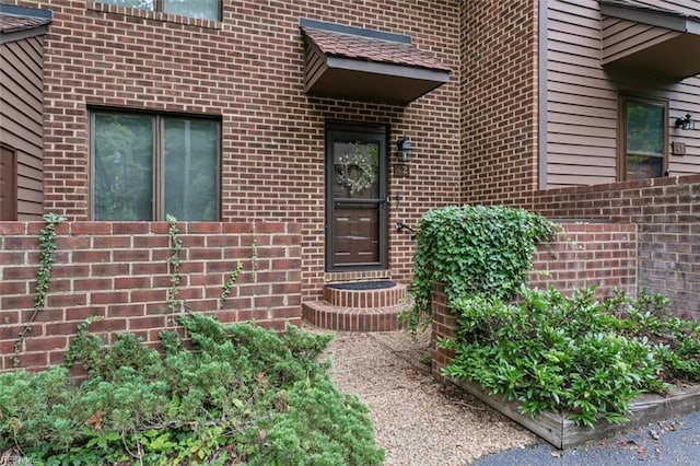 view of exterior entry featuring brick siding