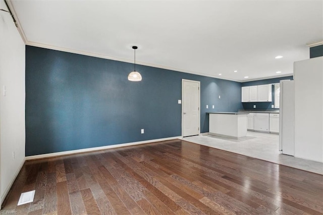 unfurnished living room featuring recessed lighting, crown molding, light wood-style flooring, and baseboards