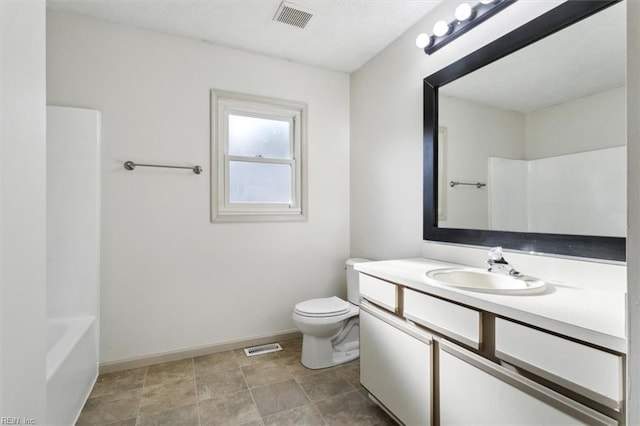 bathroom with toilet, vanity, visible vents, and baseboards