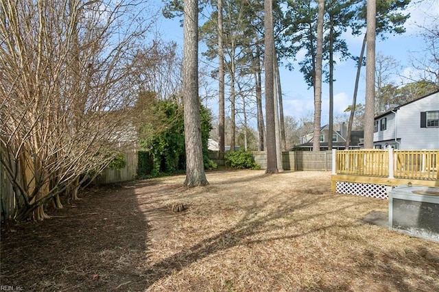 view of yard featuring a fenced backyard, a deck, and central air condition unit